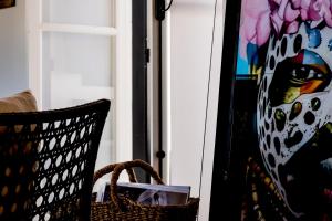 a chair next to a window with a painting at Casa BOHO in Alaminos
