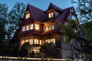 a large wooden house with its lights on at Harendzianka in Zakopane