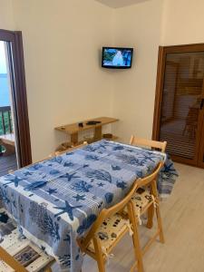 una sala da pranzo con tavolo e TV a parete di Appartamento in Costa Smeralda - Bilocale sul mare - Sea View a Olbia