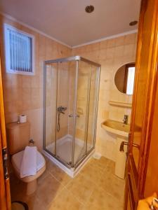 uma casa de banho com um chuveiro, um WC e um lavatório. em Nagi Beach Hotel em Gümbet