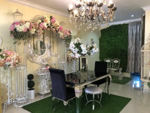 um quarto com uma mesa com flores e um lustre em AAM Hotel em Kota Bharu