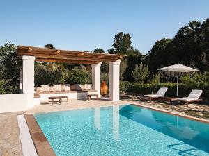a swimming pool with a pergola next to a pool at Trulli Del Bosco in Alberobello