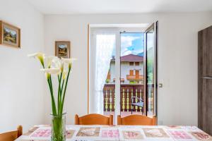 een vaas met bloemen op een tafel met een raam bij Casa Alberta in Pieve Di Ledro