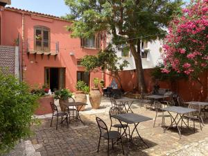 a patio with tables and chairs in front of a building at Baglio Buccellato in Scopello