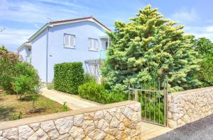 a house with a fence and a tree at Apartment Anja in Krk