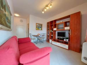 a living room with a pink couch and a table at Serena 2-8 in Lido di Pomposa