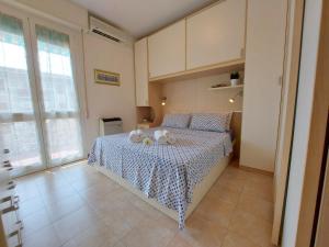 a bedroom with a bed with a blue and white bedspread at Serena 2-8 in Lido di Pomposa +33 photos