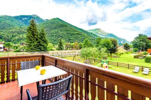 a balcony with a table and chairs and mountains at Casa Alberta in Pieve Di Ledro