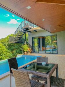 uma casa com piscina com mesa e cadeiras em Baan View Talay Pool Villas em Thong Nai Pan Yai