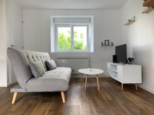 a living room with a couch and a tv and a table at Duplex calme et cosy in Concarneau