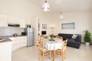 a kitchen and living room with a table and a couch at Apartments Dujmovic Ivo 1 in Baška
