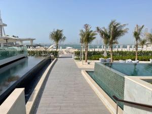 un resort con piscina e palme di ADDRESS BEACH Residence a Dubai
