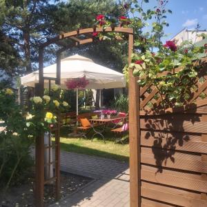 a garden with a wooden arbor with flowers at Nadmorskie Apartamenty in Ustka