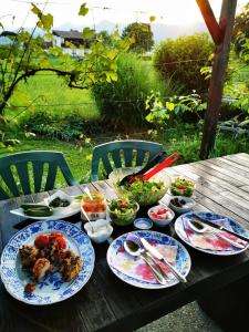 a wooden table with plates of food on it at MERIKOTKA - a cozy wooden cottage, sLOVEnia in Braslovče