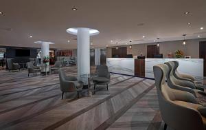 een lobby met stoelen en een bar in een gebouw bij George Limerick Hotel in Limerick