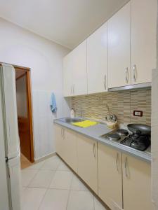 eine Küche mit weißen Schränken und einer Arbeitsplatte in der Unterkunft Beach Apartaments in Durrës