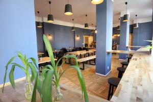 um restaurante com mesas de madeira, cadeiras e plantas em Blue Doors Hostel KTV em Rostock