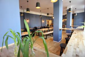 un restaurante con mesas de madera, sillas y plantas en Blue Doors Hostel KTV, en Rostock