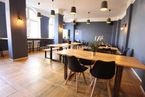 een eetkamer met houten tafels en stoelen bij Blue Doors Hostel KTV in Rostock