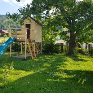 a play house with a slide and a tree at Osada nad Potokiem in Szczyrk