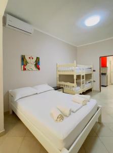ein Schlafzimmer mit einem großen weißen Bett in einem Zimmer in der Unterkunft Beach Apartaments in Durrës