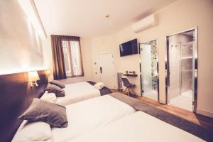 um quarto de hotel com duas camas e uma cabina de duche ao nível do chão em Hostal Marlasca em Madri
