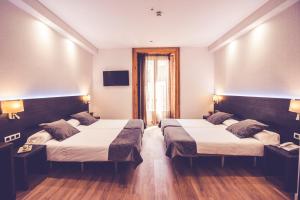 a hotel room with two beds and a window at Hostal Marlasca in Madrid