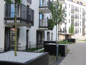 an apartment building with a tree in a courtyard at EL Apartments - Hercules in Poznań