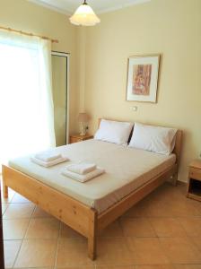a bedroom with a large bed with two towels on it at Oikia Dinachris in Agios Georgios