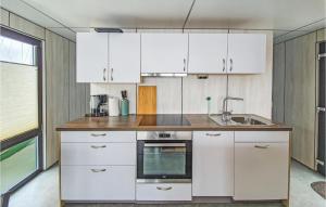 a kitchen with white cabinets and a sink at Mermaid-hausboote 2 in Lelystad