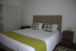 a bedroom with a large bed with two pillows at Apartamento de Vila Franca do Campo in Vila Franca do Campo
