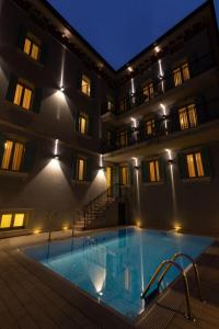 una piscina di fronte a un edificio di notte di Mefuta Hotel a Gardone Riviera