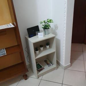 a white shelf with plants and a laptop on it at Casa Magnolia in Arena Metato