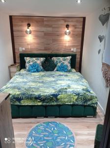 um quarto com uma cama com um edredão azul em Apartamenty Sowianka em Ludwikowice Kłodzkie