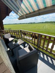 a balcony with a table and chairs and a field at Ferienwohnung Bock im Seenland in Hoyerswerda