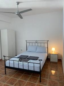 1 dormitorio con 1 cama y ventilador de techo en Villa Aphrodite, en Koundouros