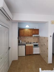 a kitchen with white appliances and wooden cabinets at Bralos Apartments in Patitiri +17 photos