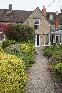 une maison avec un chemin en gravier devant elle dans l'établissement The Nurseries Bed and Breakfast Fairford, à Fairford