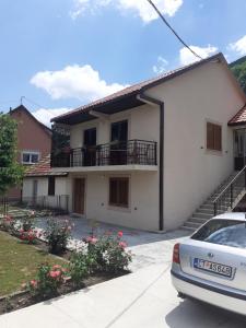 una casa con un coche aparcado delante de ella en Apartman Damjanovic en Cetinje