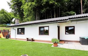 una casa blanca con un banco en un patio en Nice Home In Techelsberg With 1 Bedrooms And Wifi, en Techelsberg am Worthersee