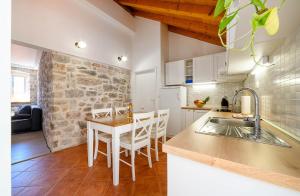 a kitchen with a sink and a table with chairs at Apartments Festum in Šibenik
