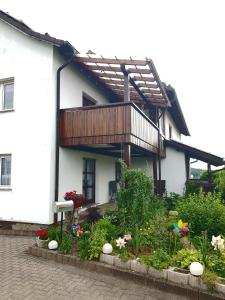 a white house with a balcony and some flowers at Isoldes Ferienparadies in Heiligkreuzsteinach