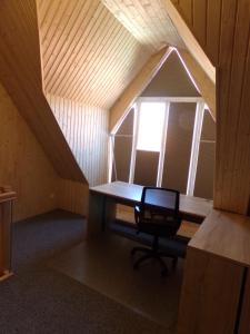 Zimmer im Dachgeschoss mit einem Schreibtisch und einem Fenster in der Unterkunft Zehnthof in Geldersheim
