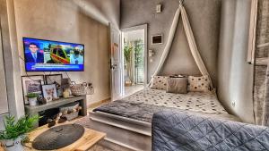 ein Schlafzimmer mit einem Bett und einem Fernseher an der Wand in der Unterkunft BeachHouse in Arkondikó