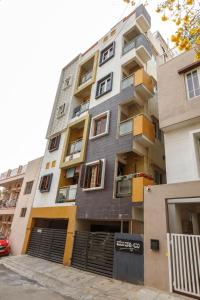 a tall apartment building with yellow and gray at Cosy Penthouse with High speed wifi-UPS near WTC-IISC in Bangalore