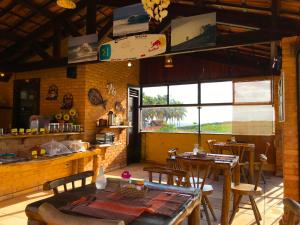 a restaurant with tables and a surfboard hanging from the ceiling at Hotel Pousada Beleza das Ondas in Cumbuco