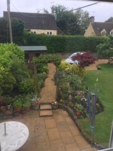 un jardín con plantas y flores en un patio en The Nurseries Bed and Breakfast Fairford en Fairford
