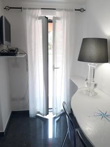 a room with a table with a lamp and a window at Villa Patrizia in La Spezia