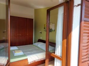 małą sypialnię z lustrem i łóżkiem w obiekcie P&Z Apartments w Rabie
