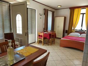 a bedroom with a bed and a dining room with a table at P&Z Apartments in Rab